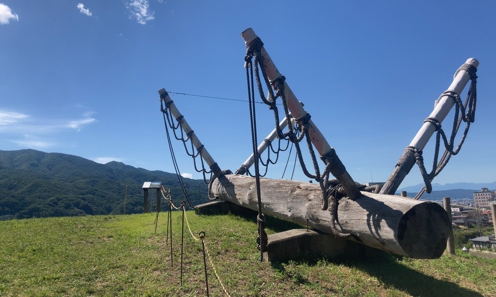 御柱祭で曳き下ろされる巨木の御柱。命を懸けて運ぶ信州・諏訪の伝統祭礼を象徴する光景。