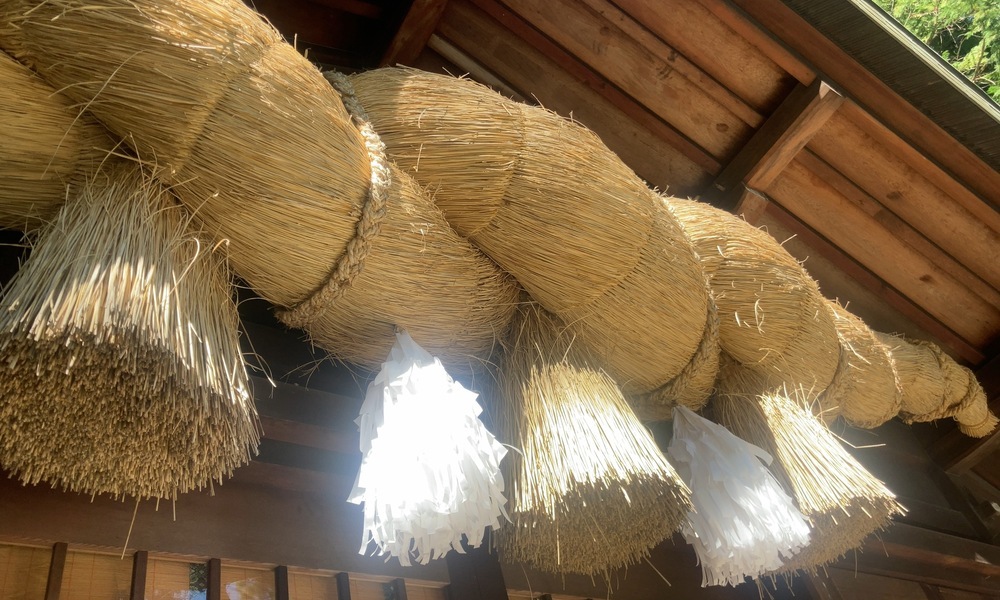 神社に掛けられた大きなしめ縄。共同体の絆を象徴する神聖な縄。