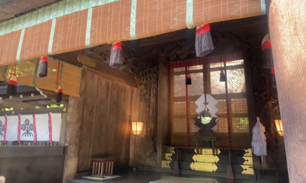 諏訪大社の社殿内に祀られた御柱。観光客の視線と祈りの空間が交差する現代の祭礼風景。