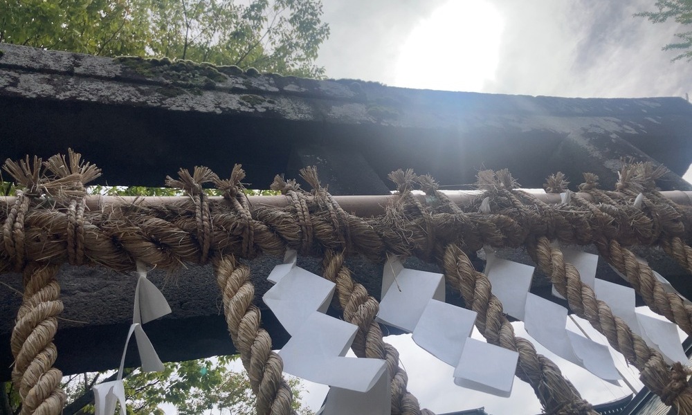 八釼神社の鳥居を見上げ、空と太陽を重ねて“在る神”を表現したショット。
