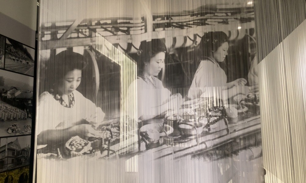 岡谷蚕糸博物館に展示されている女工たちの写真。糸を紡ぐ若い女性たちの姿が、近代日本の産業と文化の原点を静かに語っている。