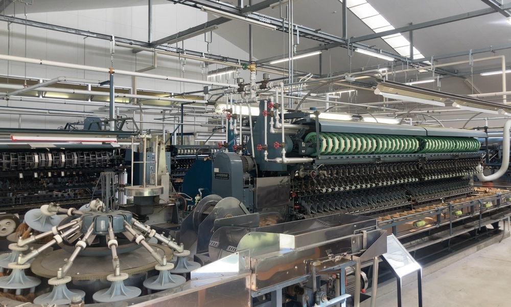 岡谷市内の現代的な製糸工場に残る自動繰糸機。かつて世界を動かしたシルク産業の技術が、いまも精密な機構として受け継がれている様子。
