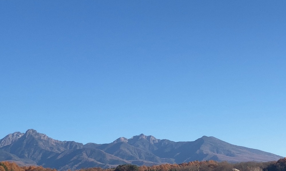 山の稜線と澄んだ空。地中で続く火と水の循環を想起させる風景