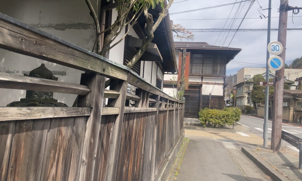 下諏訪の旧中山道と旧甲州街道がぶつかる交差点付近、木塀沿いに続く町並み