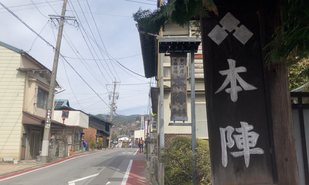 下諏訪宿本陣の木製看板と旧街道沿いの通り、宿場の格式を今に伝える風景