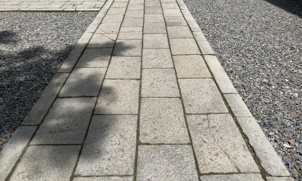 諏訪大社下社春宮の境内に続く石畳の参道。足元へ視線が落ちる静かな道。