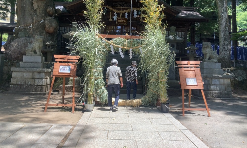 夏越の大祓で茅の輪をくぐる前に立つ参拝者