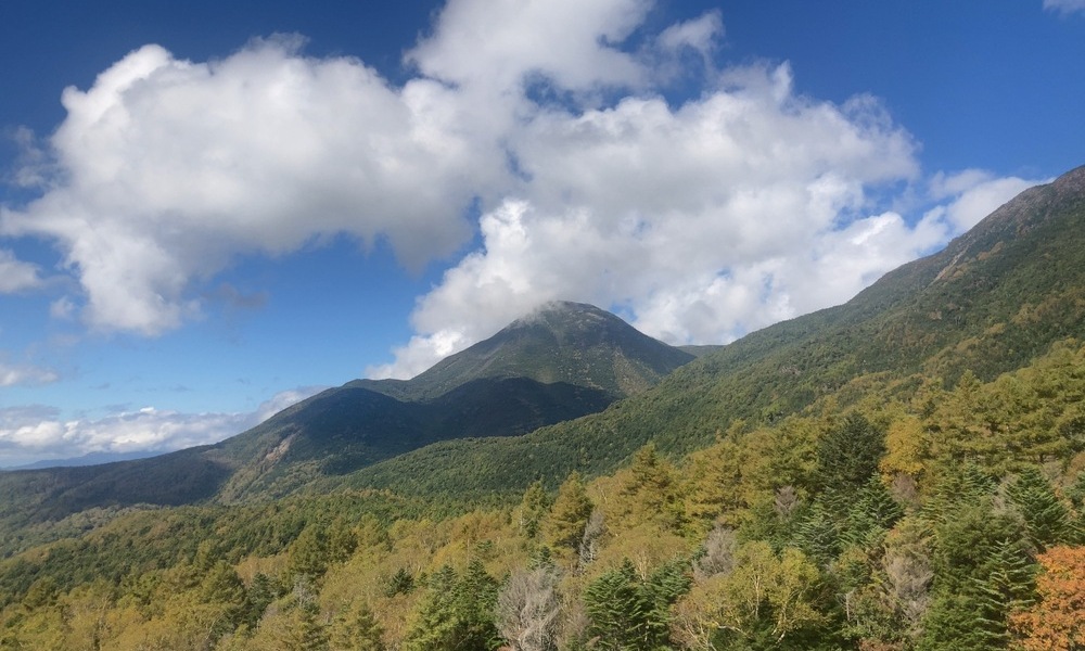 八ヶ岳連峰を覆う雲と色づく森──設計されていない自然の変化を映す山岳風景