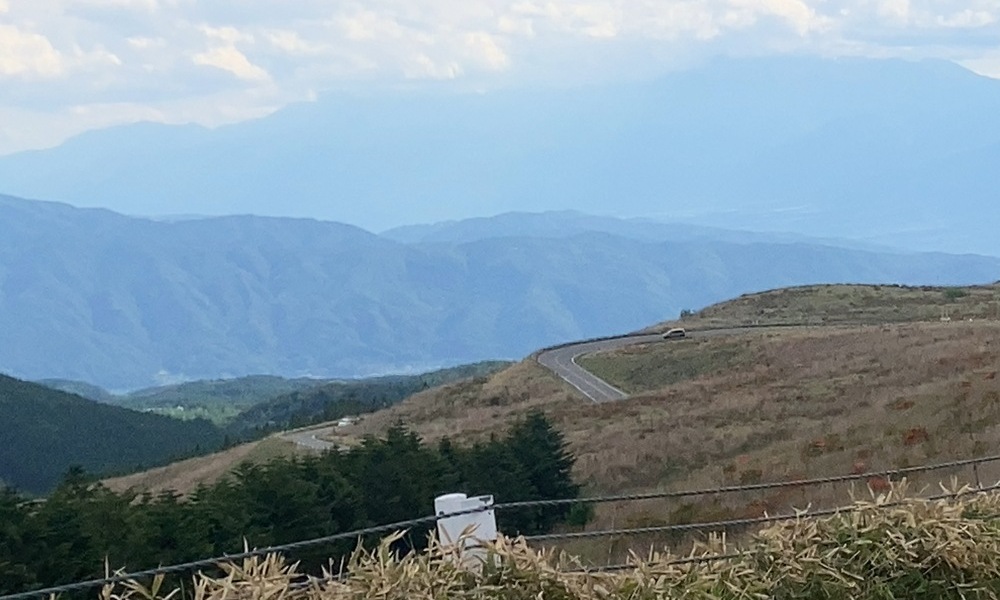 標高を上げた先から見える道と遠くの山並み